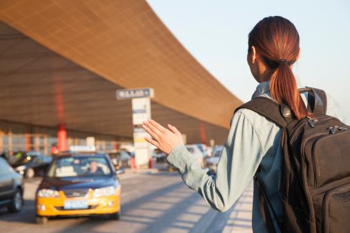 service-1 Young traveler hailing a taxi at airport