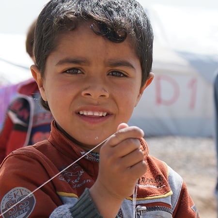 Critical Aid: Refugee Boy Recipient of Supplies