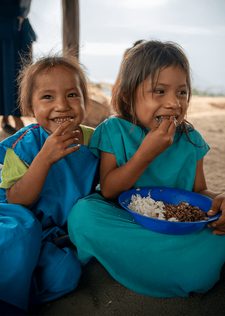 two little girls enjoy a bowl of rice